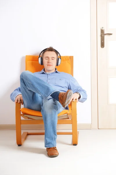 Mies kuuntelee musiikkia kuulokkeilla — kuvapankkivalokuva