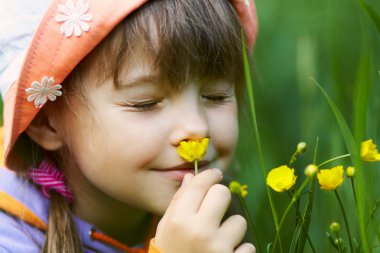 Girl smelling a flower clipart