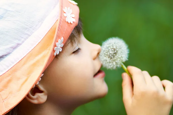 Dziewczynka wącha dandelion — Zdjęcie stockowe