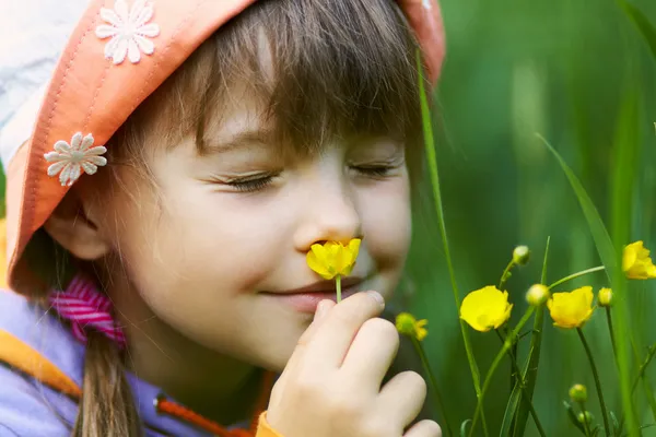 Mädchen riecht eine Blume Stockbild