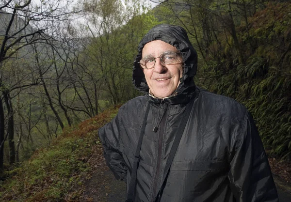 Mature man with a raincoat in nature — Stock Photo, Image