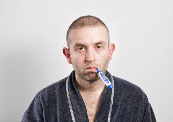 Sairas mies, jolla on lämpömittari vaakasuorassa koostumuksessa — kuvapankkivalokuva
