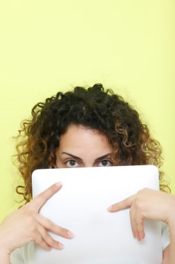 Young woman holding a Tablet computer against green background &