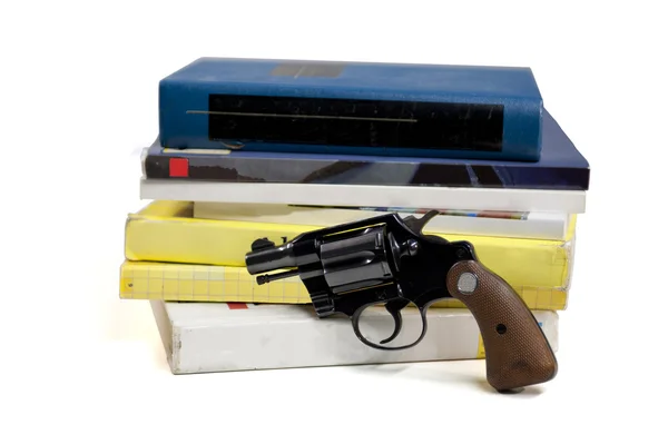 Läroböcker och pistol — Stockfoto