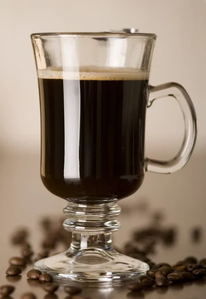 Černá káva ve skle s kávová zrna — Stock fotografie