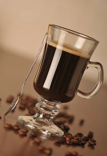Μαύρο καφέ στο ποτήρι με κόκκους καφέ — Φωτογραφία Αρχείου