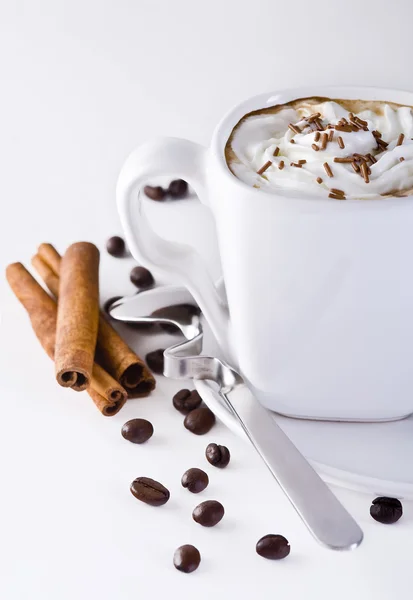 Кофе со взбитыми сливками, корицей и кофейными зёрнами — стоковое фото