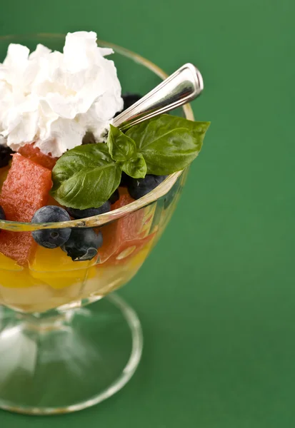 Dessert di frutta nella tazza di vetro sul retro verde — Foto Stock