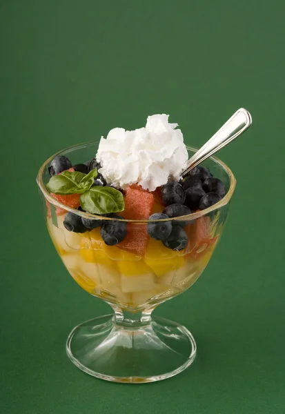 Φρούτα επιδόρπιο στο γυαλί Κύπελλο σχετικά με το πράσινο backgrund — Φωτογραφία Αρχείου