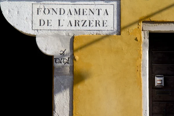 Detail van een straat plaat en geel muur — Stockfoto