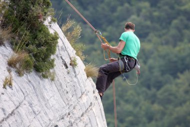 Descent of a male rock climber clipart