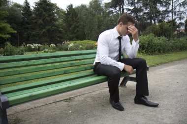 Young businessman sitting on a bench. clipart