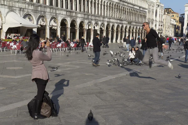 Dos turistas se divierten con las palomas  . —  Fotos de Stock