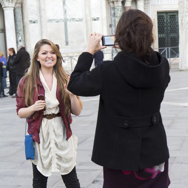 Jovem mulher tirando uma foto de seu amigo sorridente — Fotografia de Stock
