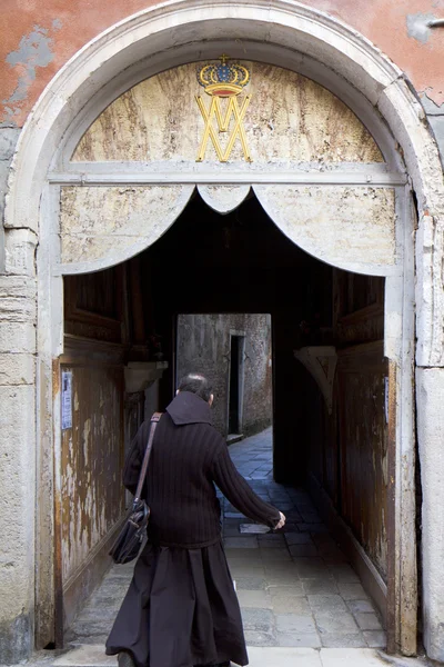 聖職者の男はドアの下を歩く — ストック写真