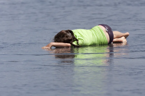 Kind in het water liggen. — Stockfoto