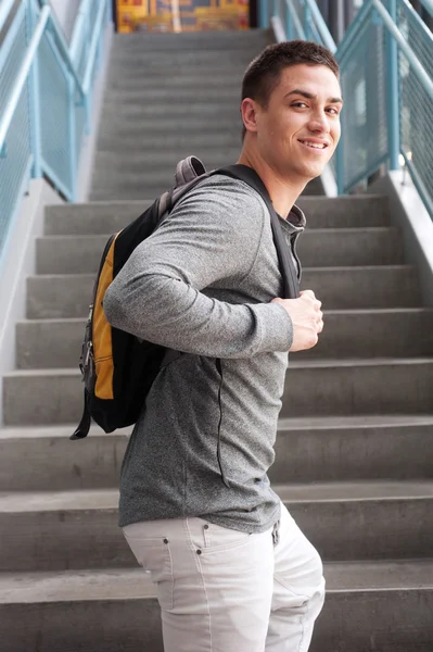 Unga manliga collegestudent med ryggsäck — Stockfoto