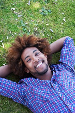 Çimlere yatan genç Afro-Amerikan erkek