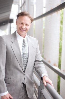 Portrait of a confident mature businessman standing outside clipart