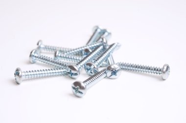 Heap of screws closeup on white background clipart