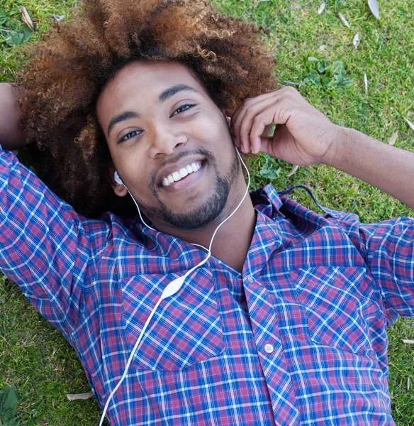 Joven afroamericano macho acostado en hierba —  Fotos de Stock