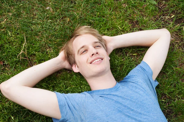 젊은 남자는 잔디에 누워 — 스톡 사진