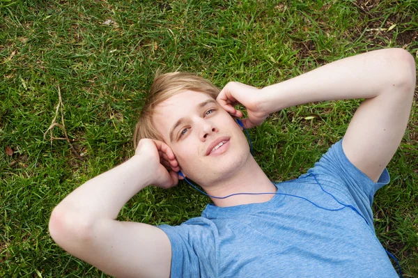 Młody mężczyzna leżąc na trawie — Zdjęcie stockowe