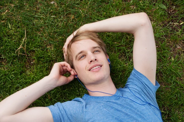 Jeune homme couché dans l'herbe — Photo