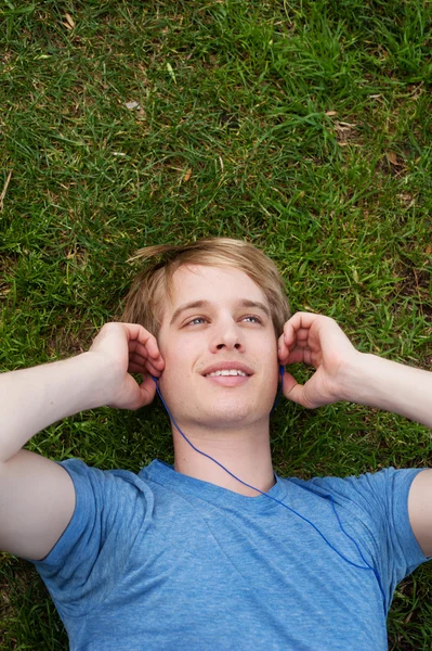 躺在草地的年轻男性 — 图库照片