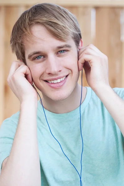 Closeup of young male listening to music — Stock Photo, Image