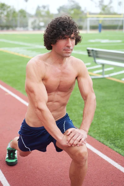Athletischer männlicher Läufer dehnt sich — Stockfoto