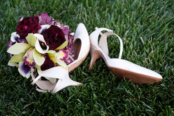 Chaussures de mariée élégantes et un bouquet — Photo