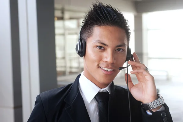 Unga asiatiska affärsman med ett headset — Stockfoto