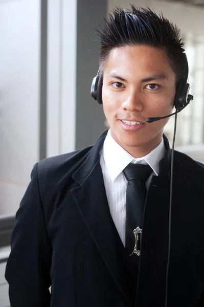 Unga asiatiska affärsman med ett headset — Stockfoto