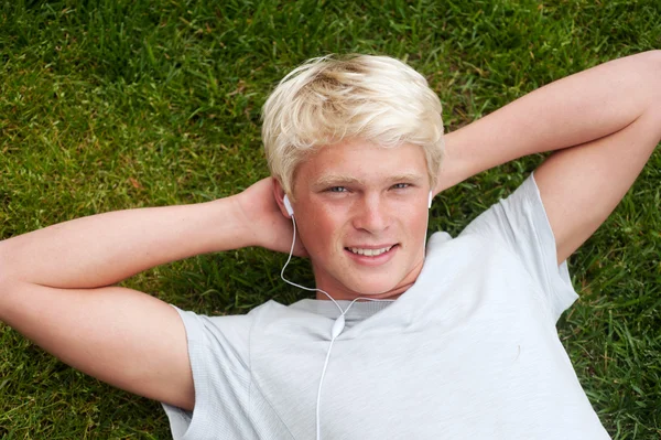 Jovem adolescente deitado na grama — Fotografia de Stock