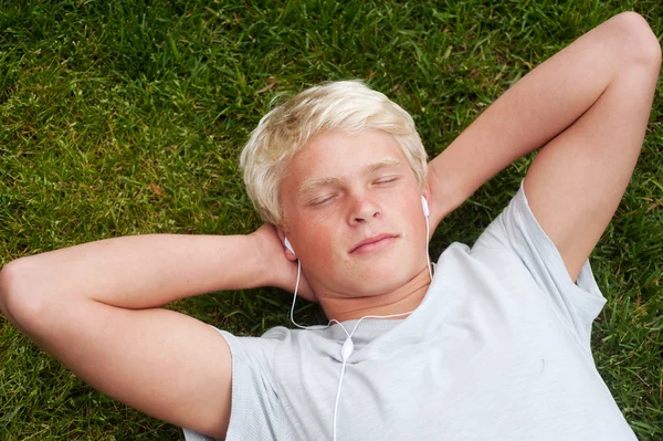 Jeune adolescent couché dans l'herbe — Photo
