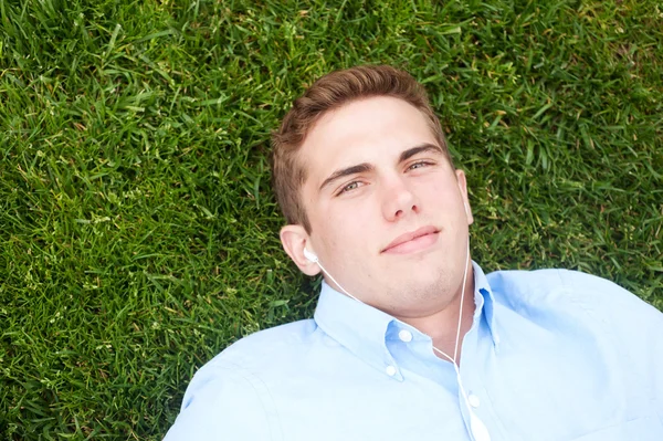 Молодой человек, лежащий в траве — стоковое фото