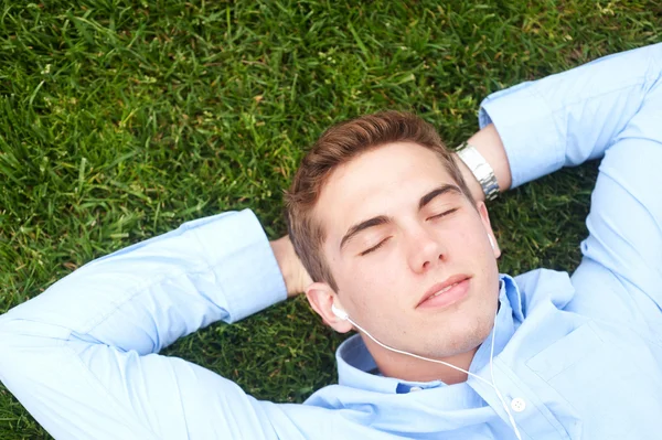 Mladý muž ležící v trávě — Stock fotografie