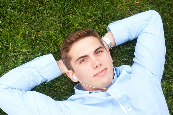 Junger Mann liegt im Gras — Stockfoto