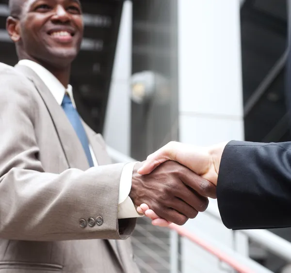 Empresário afro-americano apertando as mãos com busine caucasiano Imagem De Stock