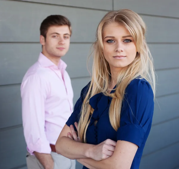 Portrait of a young businesswoman with businessman in the background — Stock Photo, Image