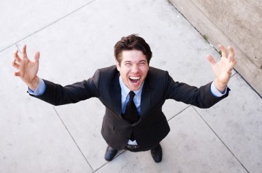 Young businessman with arms open celebrating clipart