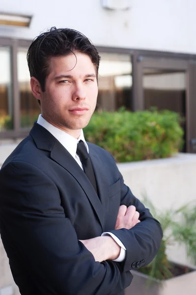 Портрет молодого бізнесмена в костюмі, що стоїть на вулиці — стокове фото