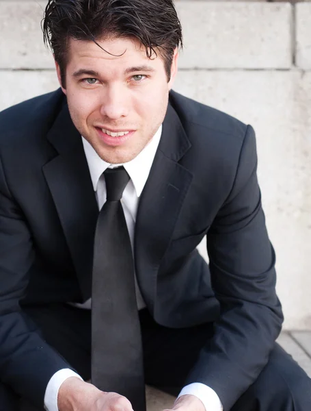 Portrait of a young businessman in suit sitting outdoors — Stock Photo, Image