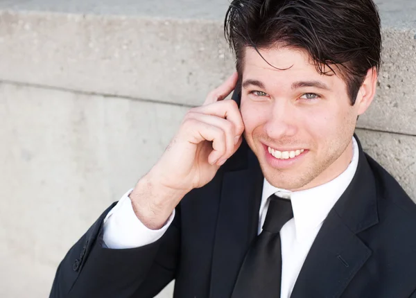 Retrato de homem de negócios bonito, jovem usando telefone celular, sorrindo — Fotografia de Stock