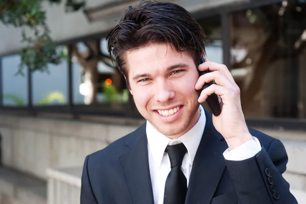 Portret przystojny, młody biznesmen za pomocą telefonu komórkowego, uśmiechając się — Zdjęcie stockowe