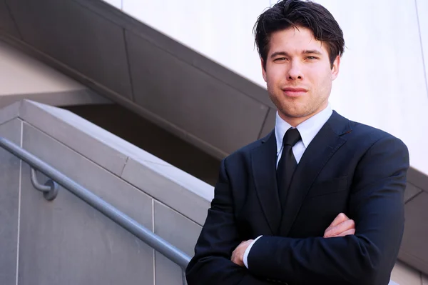 Portrait of a young businessman in suit standing outdoors — Stock Photo, Image