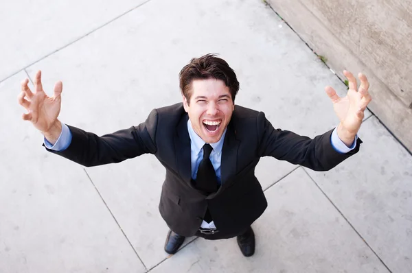 Young businessman with arms open celebrating Stock Photo