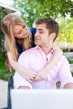 Portrait of a happy young professional couple using laptop clipart