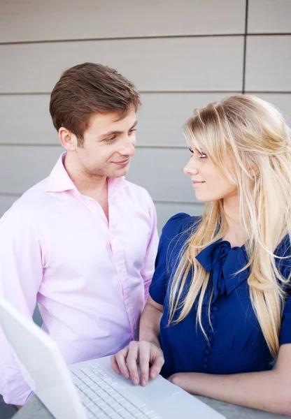 Portrait of a happy young professional couple using laptop — Stock Photo, Image